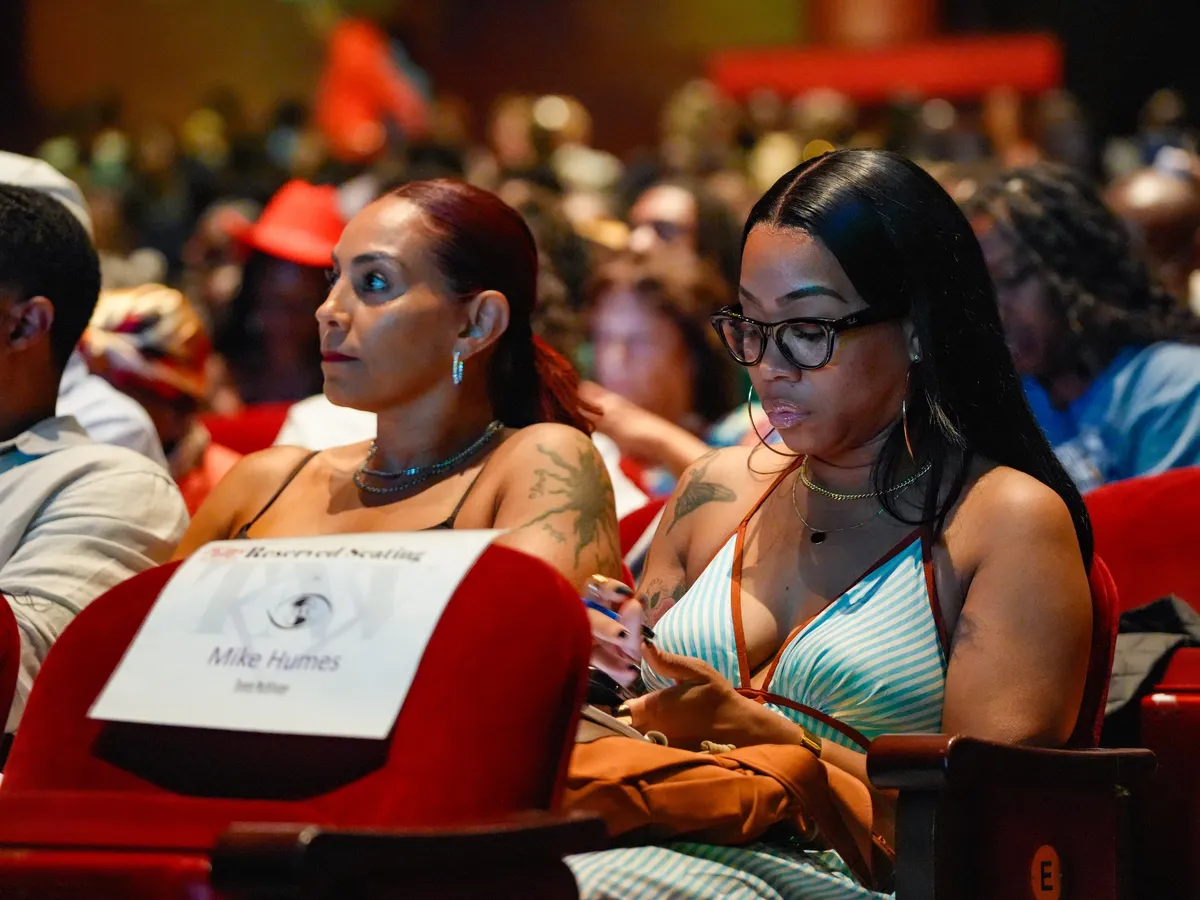 Attendees in reserved front-row seats taking notes