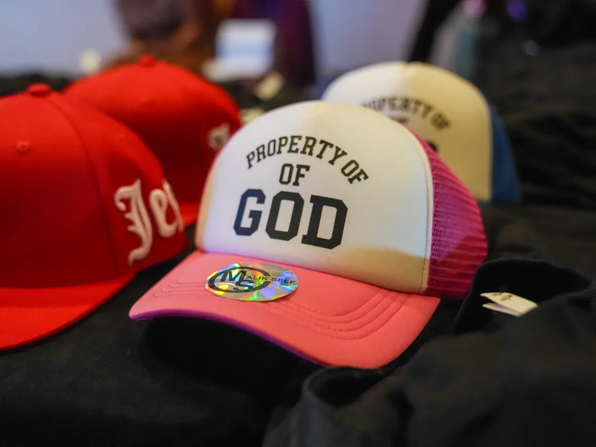 Faith-themed caps on display at an event table